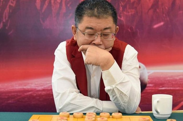 李来群在棋盘前托腮思考